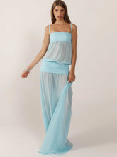 Woman wearing a light blue dress against a plain background